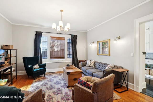 living room with hardwood / wood-style flooring, ornamental molding, and an inviting chandelier