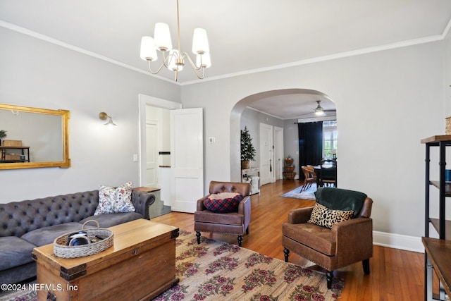 living room with crown molding, wood-type flooring, and ceiling fan with notable chandelier