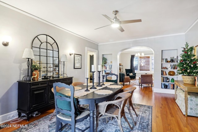 dining room featuring hardwood / wood-style flooring, ceiling fan with notable chandelier, and crown molding