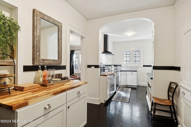 kitchen with white cabinetry, plenty of natural light, wooden counters, and wall chimney range hood