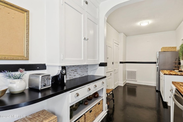 kitchen featuring wood counters, backsplash, white cabinets, crown molding, and stainless steel appliances