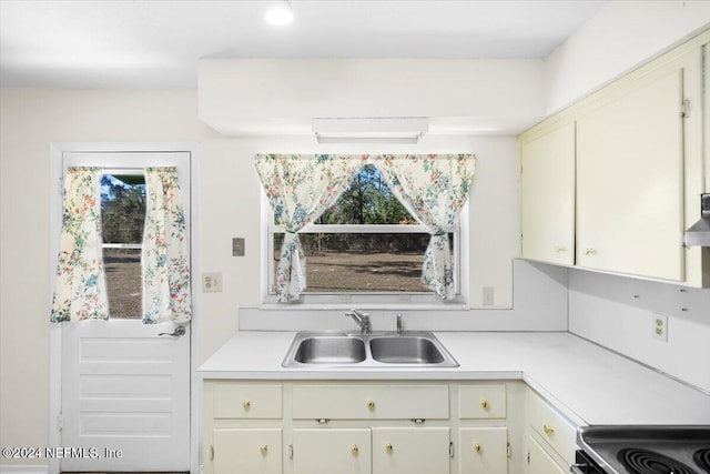 kitchen with wall chimney range hood and sink