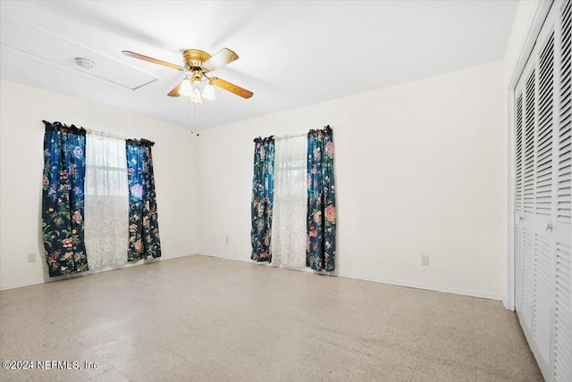 unfurnished bedroom featuring ceiling fan and a closet