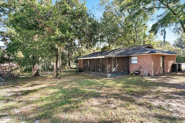 view of property exterior featuring a sunroom and a lawn