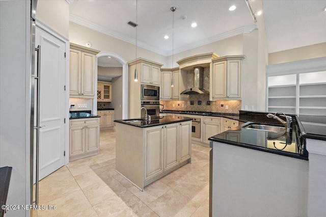 kitchen with pendant lighting, a kitchen island with sink, sink, wall chimney exhaust hood, and appliances with stainless steel finishes