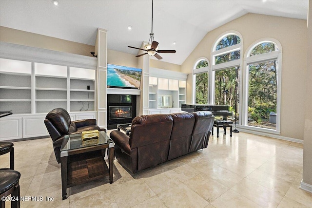 living room with built in features, vaulted ceiling, ceiling fan, and light tile patterned flooring