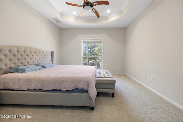 bedroom featuring a tray ceiling, ceiling fan, carpet floors, and ornamental molding