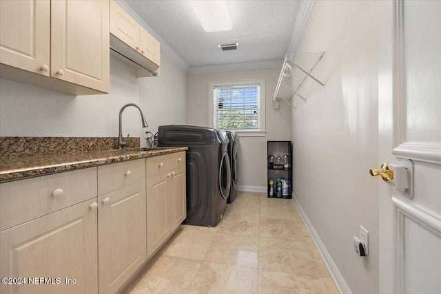 washroom with cabinets, a textured ceiling, crown molding, sink, and washing machine and dryer