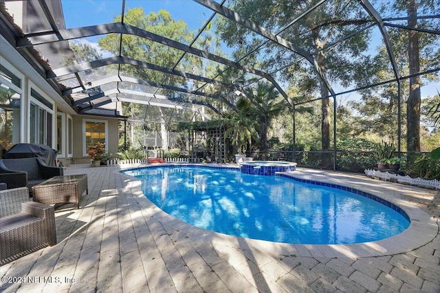 view of swimming pool with an in ground hot tub, grilling area, a lanai, and a patio area