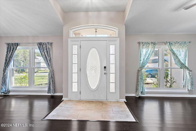 entrance foyer with hardwood / wood-style floors and a textured ceiling