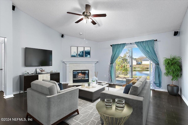 living room featuring hardwood / wood-style flooring, vaulted ceiling, ceiling fan, and a water view