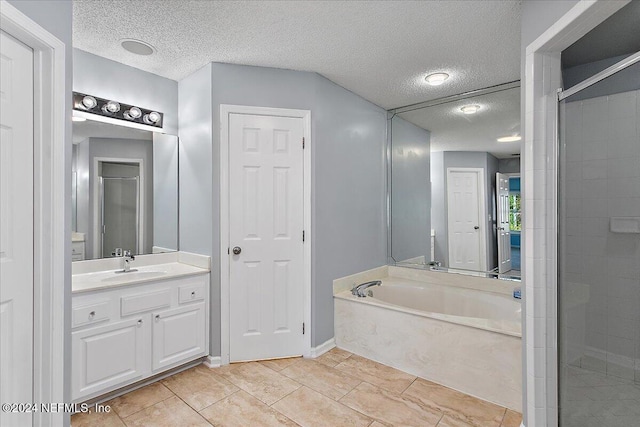 bathroom with separate shower and tub, tile patterned floors, and a textured ceiling