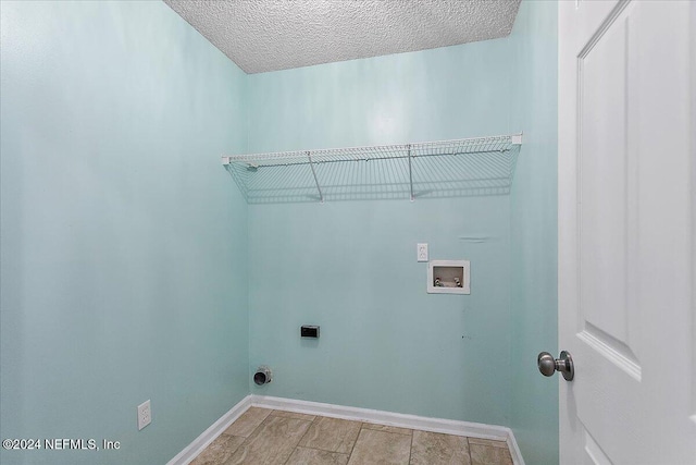 clothes washing area with washer hookup, a textured ceiling, and electric dryer hookup