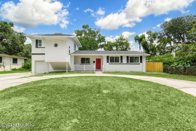 view of front facade featuring covered porch, a garage, and a front lawn