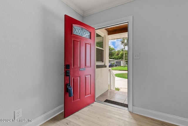 foyer entrance with crown molding and light hardwood / wood-style floors