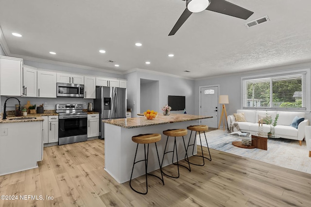 kitchen with sink, light hardwood / wood-style flooring, white cabinets, and appliances with stainless steel finishes