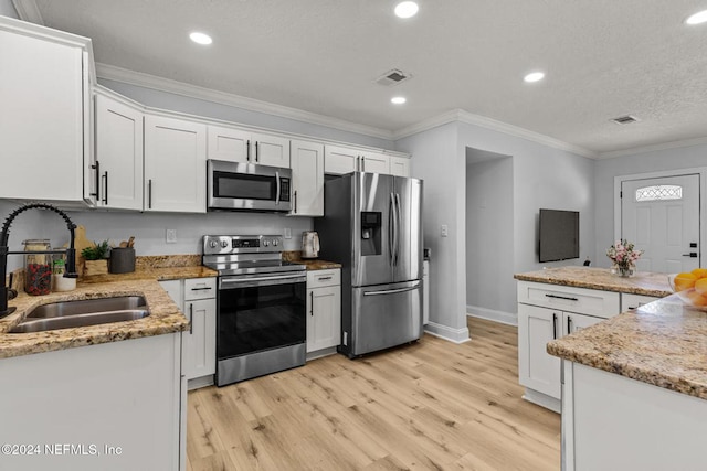 kitchen featuring light wood-type flooring, stainless steel appliances, crown molding, sink, and white cabinets