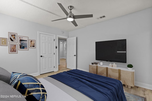 bedroom featuring ceiling fan, a textured ceiling, and hardwood / wood-style flooring