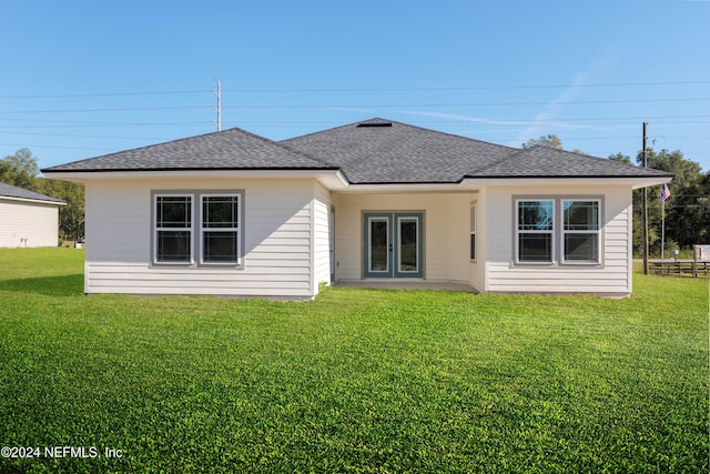 back of property with french doors and a lawn