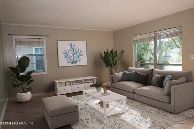 living room with tile patterned flooring and ornamental molding