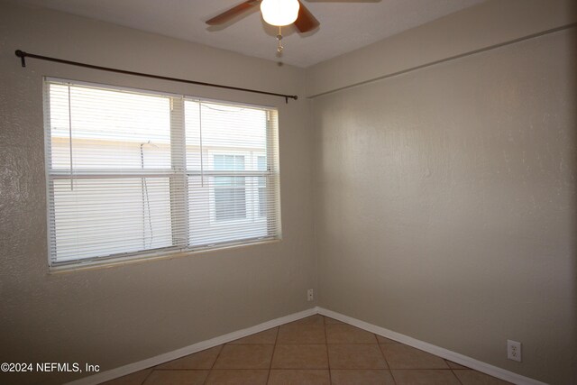 tiled empty room featuring ceiling fan