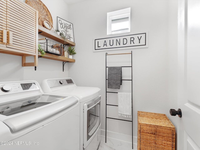 washroom featuring washing machine and clothes dryer and cabinets