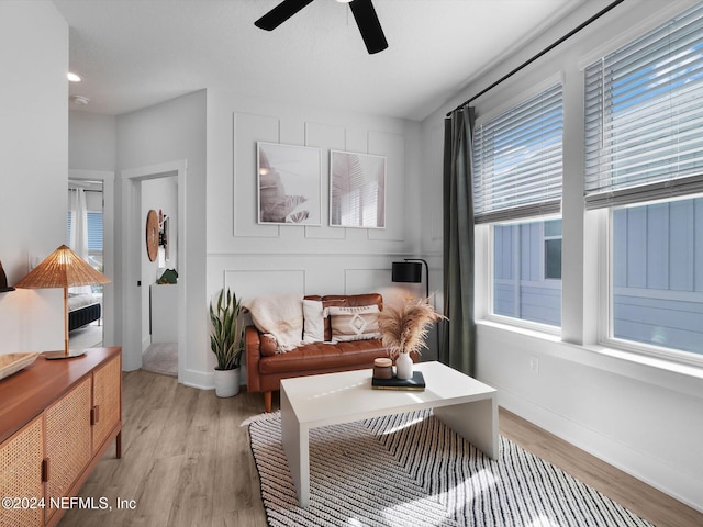 living room with ceiling fan and light wood-type flooring