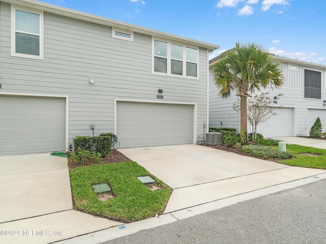 view of front of property with a garage and central air condition unit