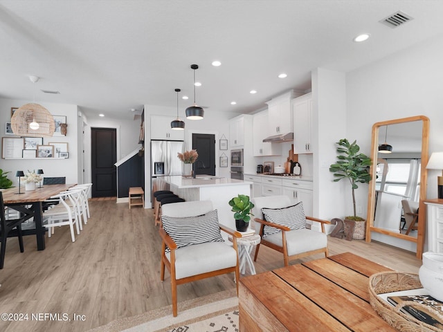 living room featuring sink and light hardwood / wood-style floors