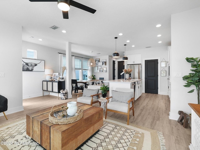 living room featuring ceiling fan and light wood-type flooring