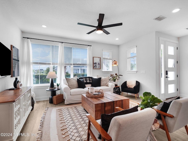 living room featuring ceiling fan and light hardwood / wood-style floors