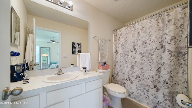 bathroom with vanity, a shower with shower curtain, ceiling fan, toilet, and a textured ceiling