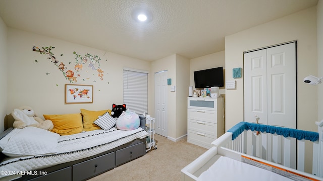 carpeted bedroom with a textured ceiling and a closet