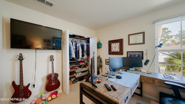 home office with a textured ceiling and light carpet