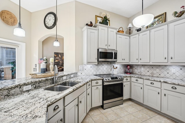 kitchen with pendant lighting, sink, decorative backsplash, white cabinetry, and stainless steel appliances