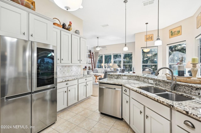 kitchen featuring pendant lighting, white cabinets, sink, ceiling fan, and appliances with stainless steel finishes