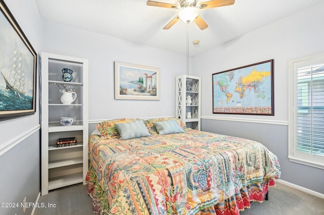 carpeted bedroom featuring ceiling fan and a textured ceiling