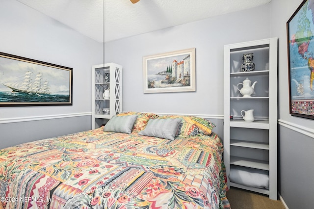 carpeted bedroom with ceiling fan and a textured ceiling