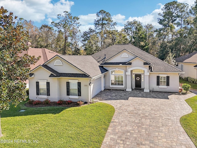 view of front of property with a garage and a front lawn