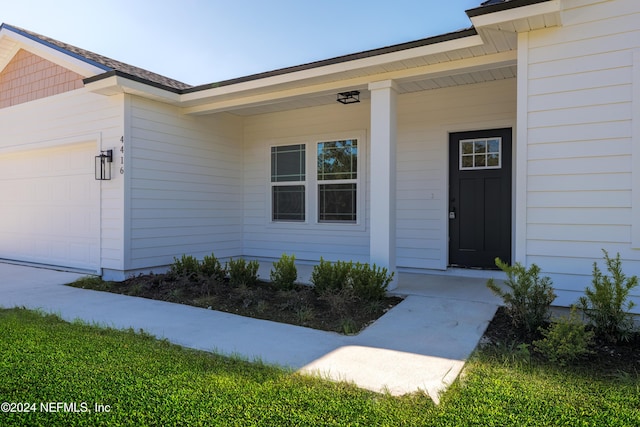 entrance to property with a porch and a garage