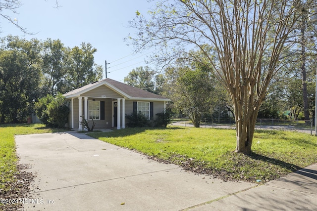 ranch-style home with covered porch and a front yard