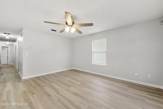 spare room with ceiling fan, light hardwood / wood-style flooring, and a textured ceiling