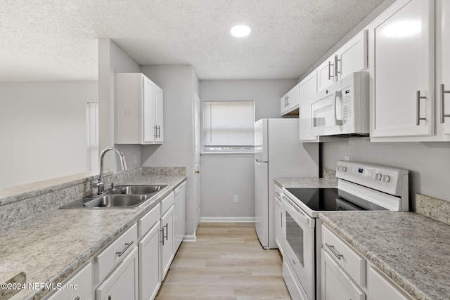 kitchen with white cabinetry, sink, a textured ceiling, white appliances, and light wood-type flooring