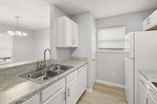 kitchen featuring white cabinets, light hardwood / wood-style flooring, a notable chandelier, and sink