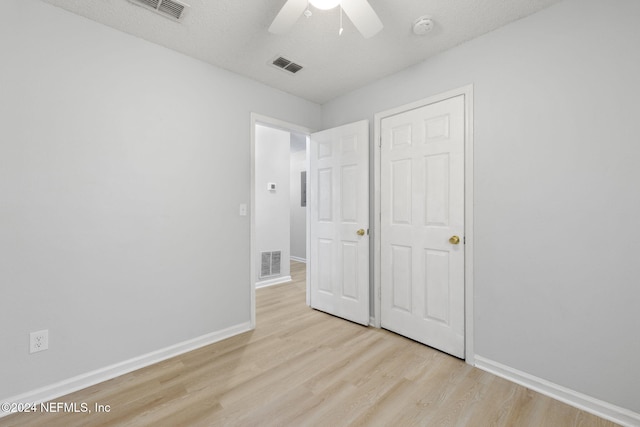 unfurnished bedroom with ceiling fan, a textured ceiling, and light hardwood / wood-style flooring