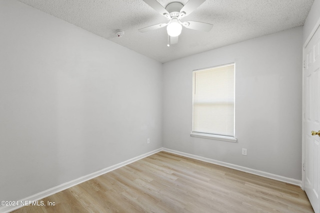 unfurnished room with ceiling fan, light hardwood / wood-style flooring, and a textured ceiling