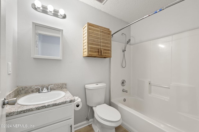 full bathroom with vanity, a textured ceiling, shower / bath combination, and toilet