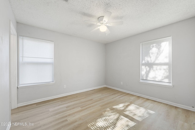 unfurnished room featuring ceiling fan, light hardwood / wood-style flooring, and a textured ceiling