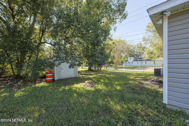 view of yard featuring central air condition unit and a shed