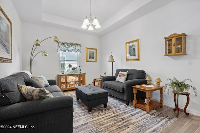 living room featuring hardwood / wood-style floors, a tray ceiling, and a notable chandelier